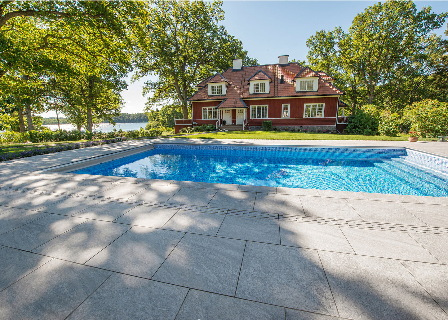 Poolområde där altanen är klädd i stenliknande utomhus klinker ifrån Bricmate Quartzit Grey