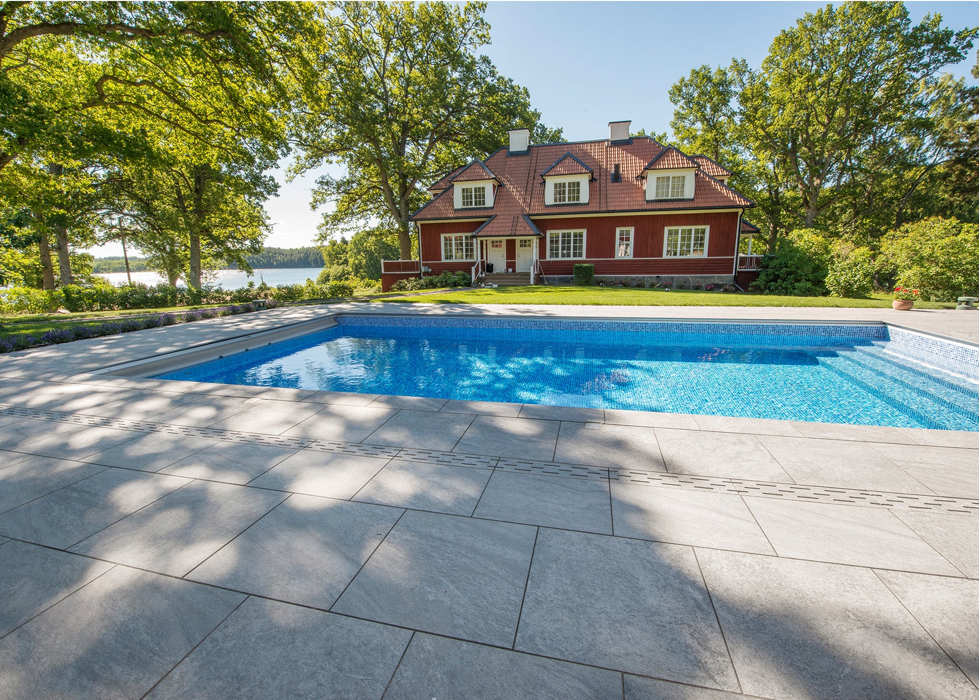 Poolområde där altanen är klädd i stenliknande utomhus klinker ifrån Bricmate Quartzit Grey