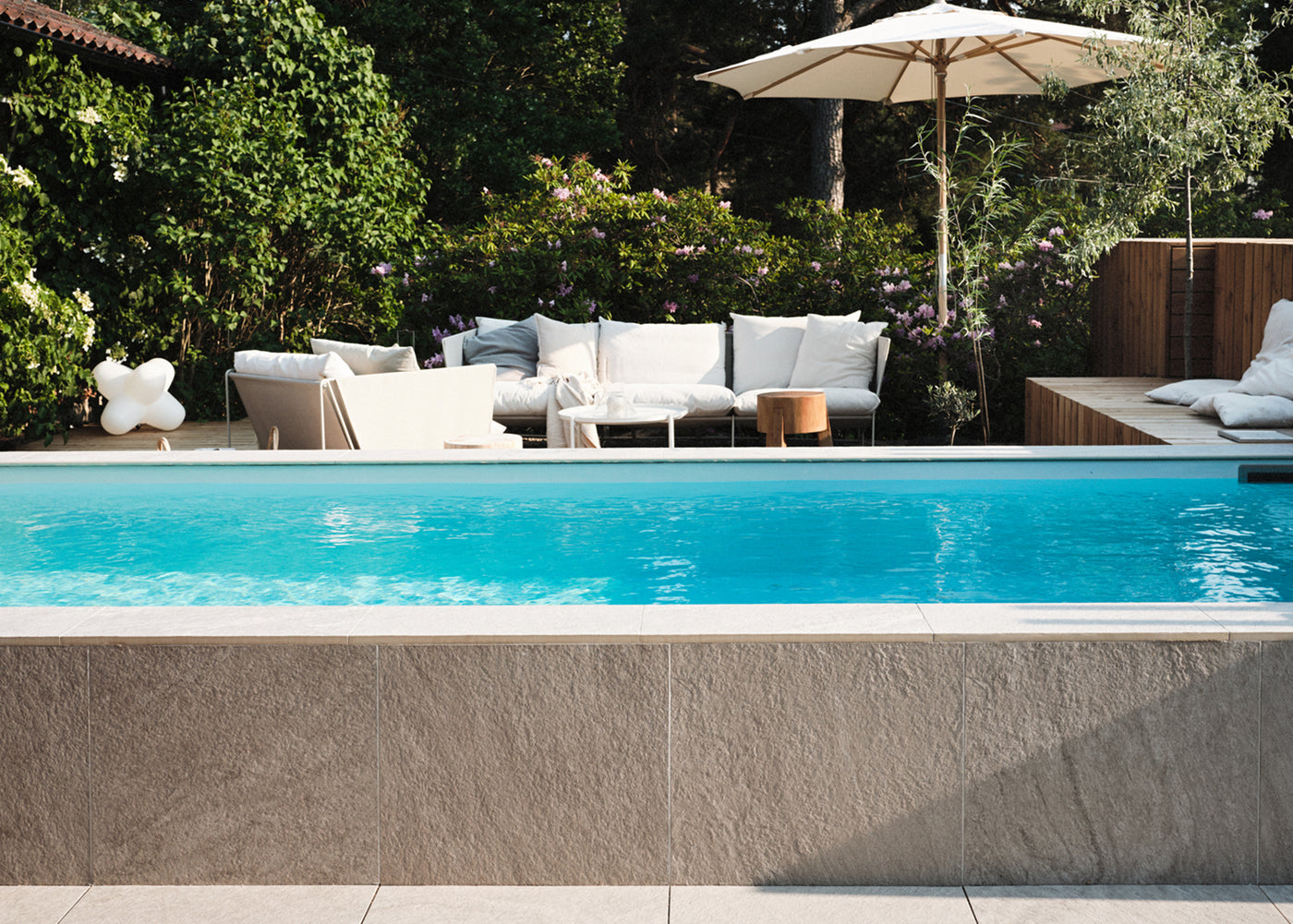 Pool klädd i beige grå mönstrad utomhus klinker ifrån Bricmate Quartzit Pearl