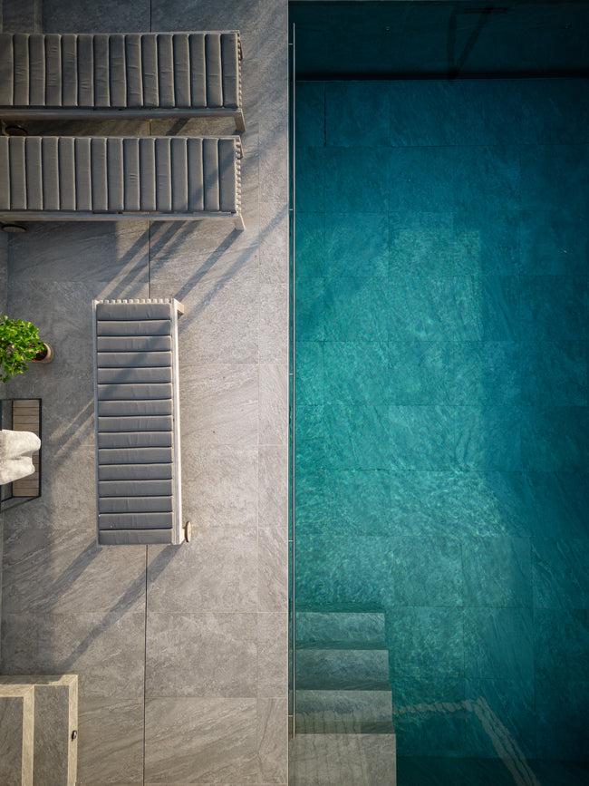 Poolområde med grått mönstrat stenliknande klinker på golv ifrån Bricmate Quartzit Grey