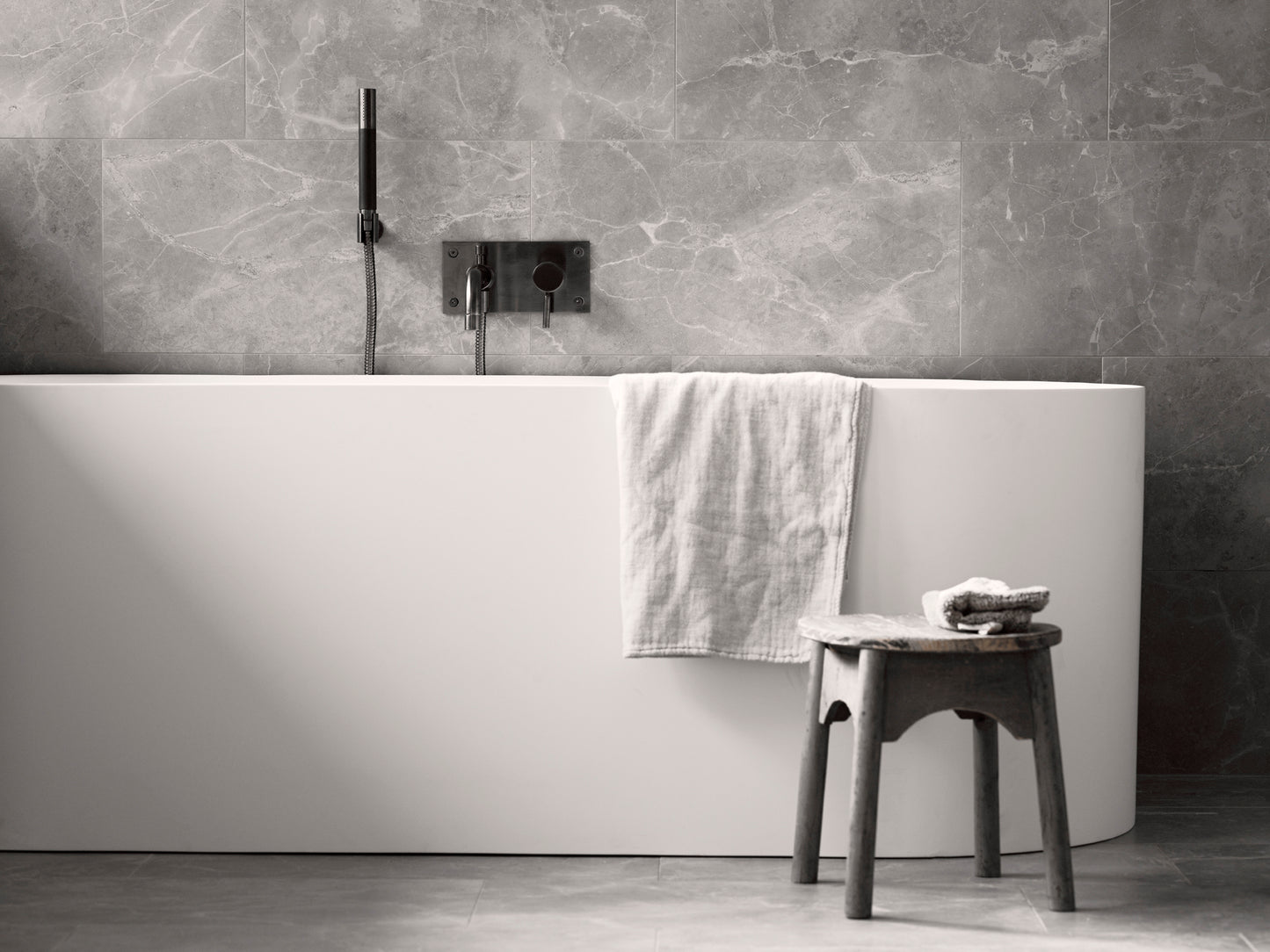 Modernt badkar med grått marmor inspirerad klinker på golv och vägg från Bricmate 