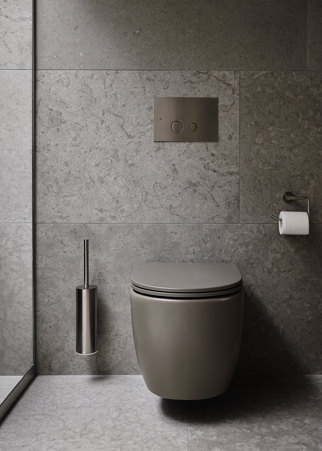 Modern toalett där vägg och golv har mönstrad ljusgrå klinker ifrån Bricmate Runö